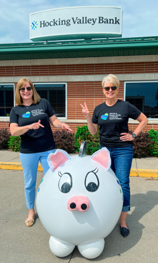 Employees standing with bank mascot, Pork Chop