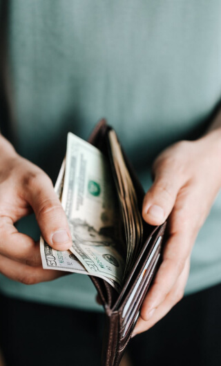 Close up of someone pulling money out of a wallet