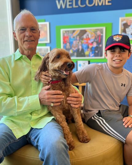 A customer visiting the bank with his dog and grandson.