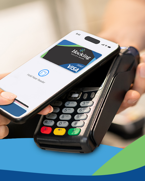 person holding phone to a merchant card reader using Hocking Valley Bank debit card mobile wallet